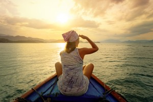 Woman traveling by boat at sunset among the islands