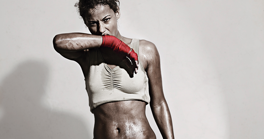 Female Boxer wiping off the sweat from her face